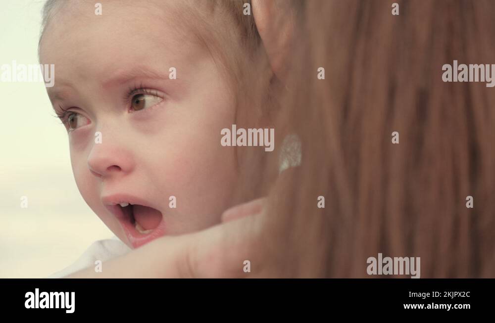 Mommy soothes baby. child is crying in park in arms of mom. family