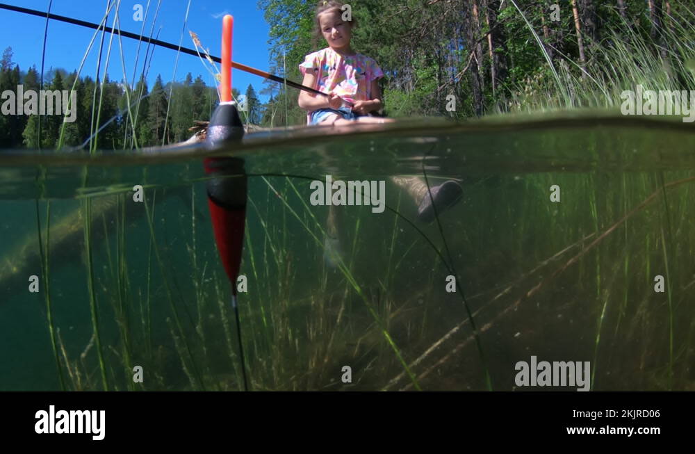 Little girl fishing with underwater view of fishing float and weed on a