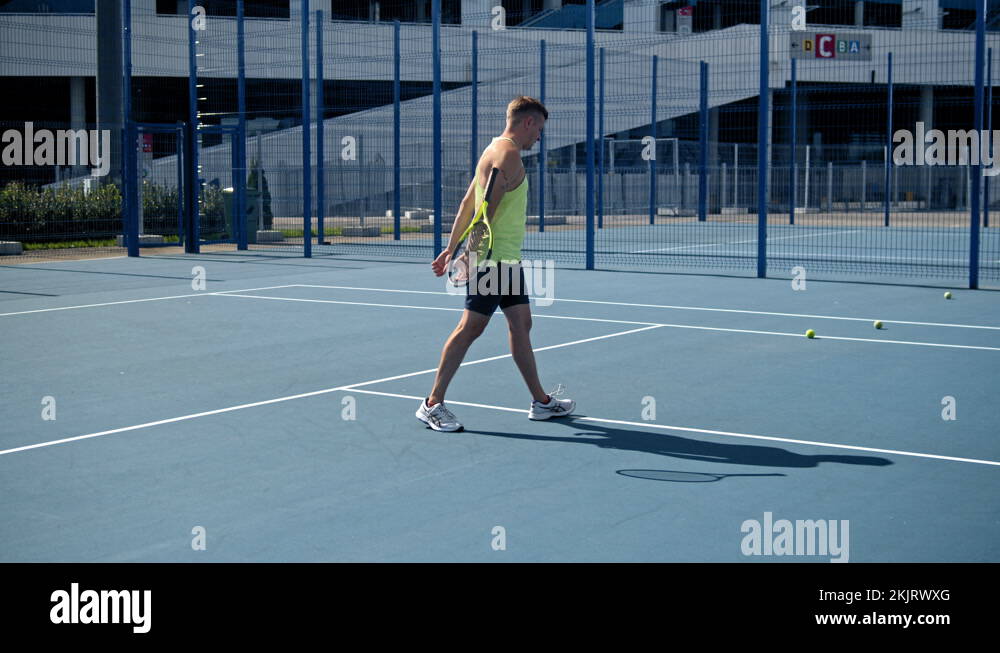 Stressed tennis player throwing and breaking a racket in anger and rage