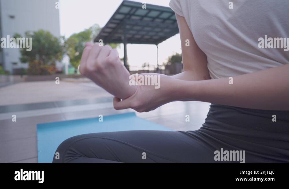 Close up woman rotating he right Wrist, joint pain during workout Stock