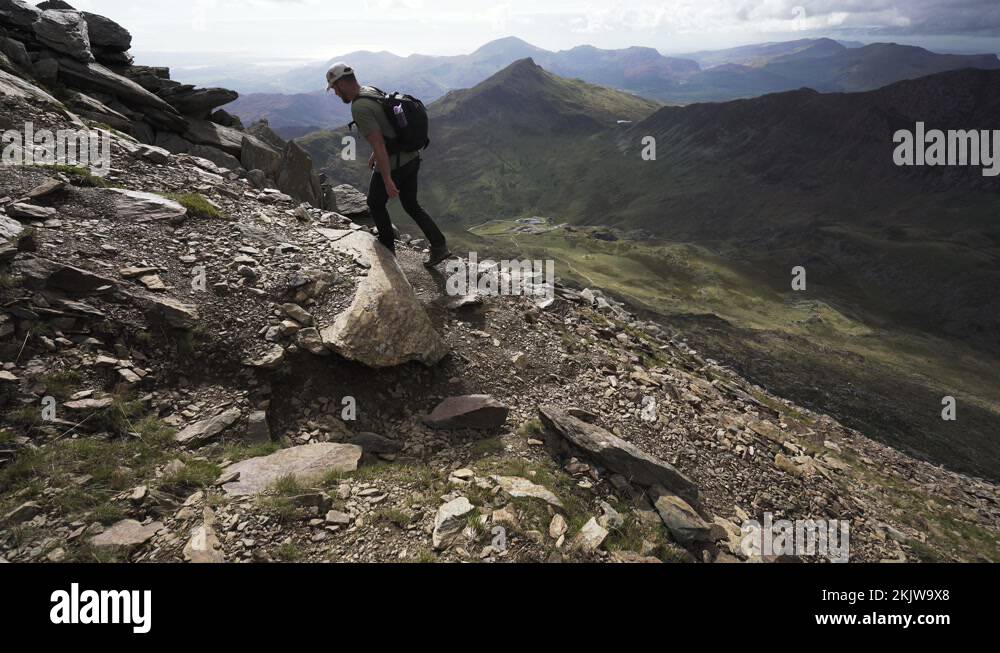 Snowdonia National Park Hiking Man On Loose Dirt And Gravel Trail Stock snowdonia-national-park-hiking-man-on-loose-dirt-and-gravel-trail-stock