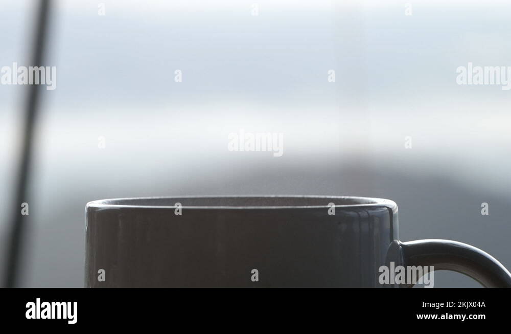 Closeup of hot coffee or tea with smoke in a white cup in the morning
