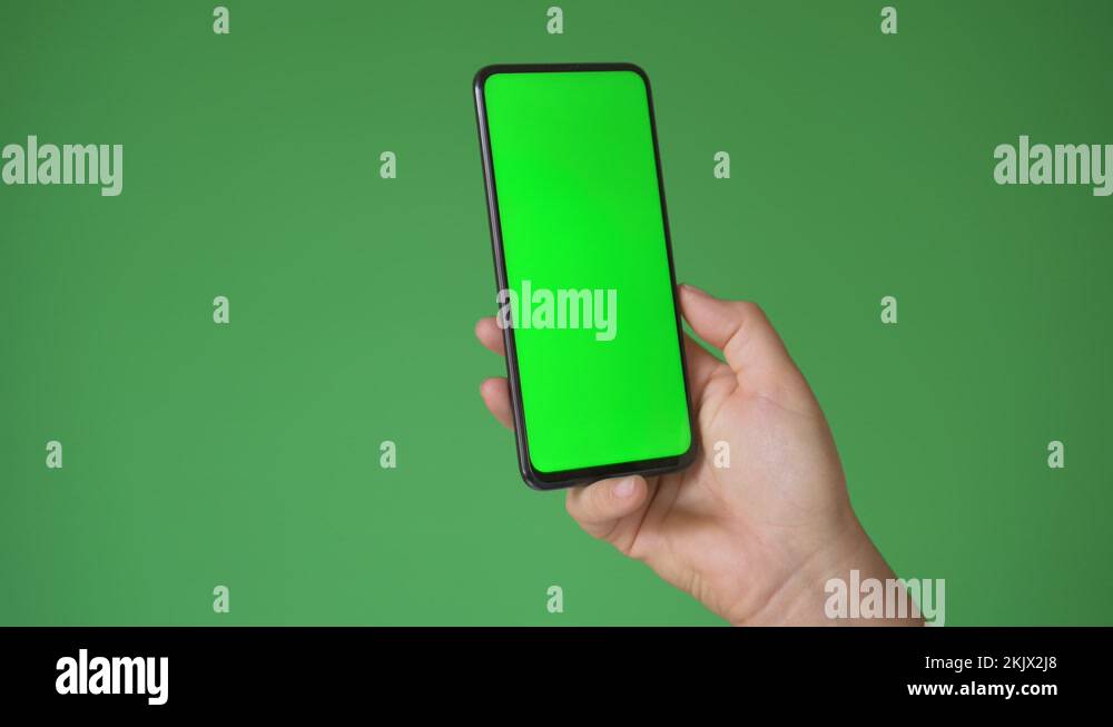 Woman hand holding the smartphone on green screen chroma key background ...