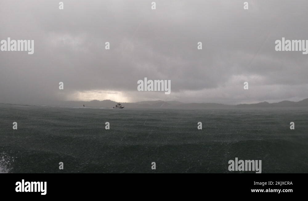Heavy rain wake boarding behind a boat stormy weather Martinique Stock