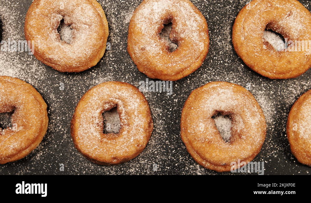 TOP VIEW Dolly shot of a rows of doughnuts with sugar powder on the