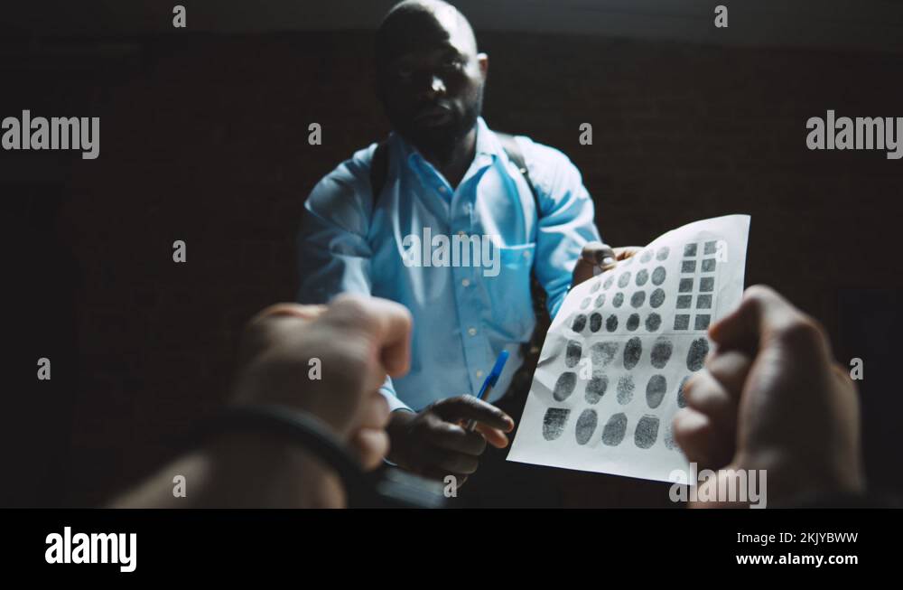 African cop showing paper with fingerprints to suspect in interrogation
