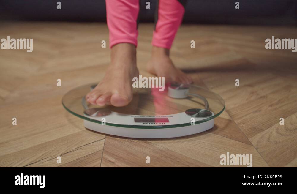 Barefoot female legs standing on weighing scale Stock Video Footage Alamy