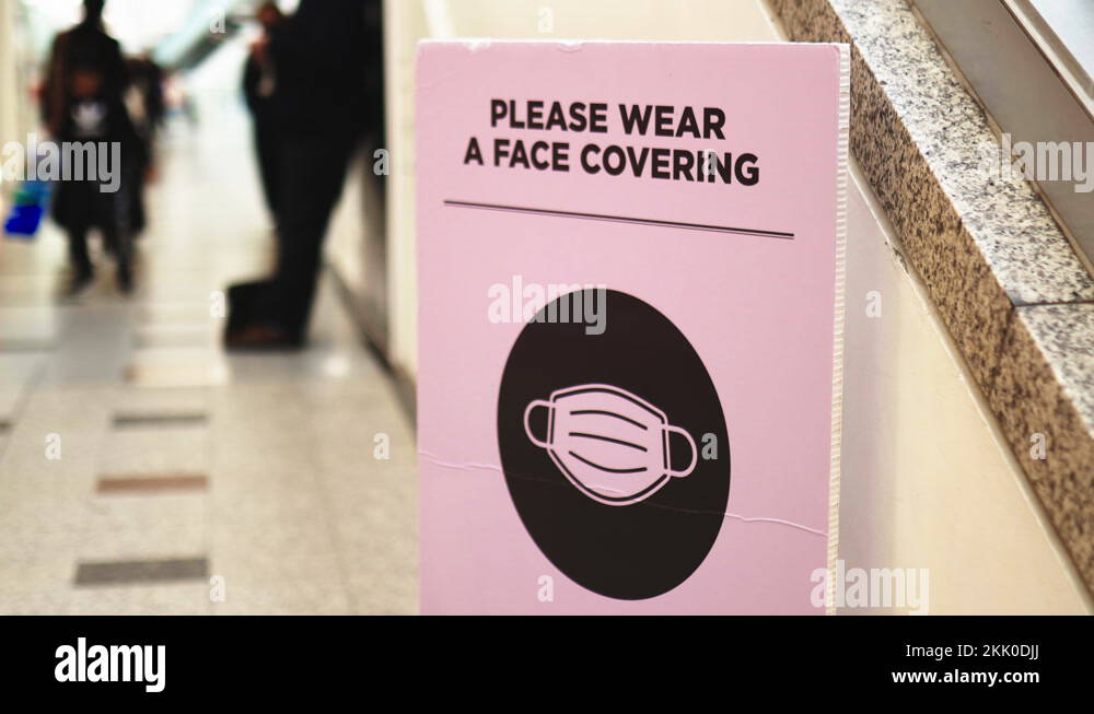 Sign next to escalators requesting people to use a face mask Stock ...