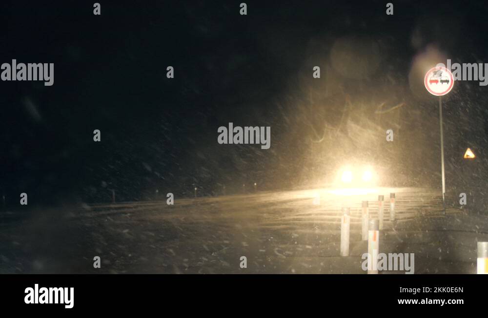 Snowstorm on highway road at night. Cars headlights illuminating ...