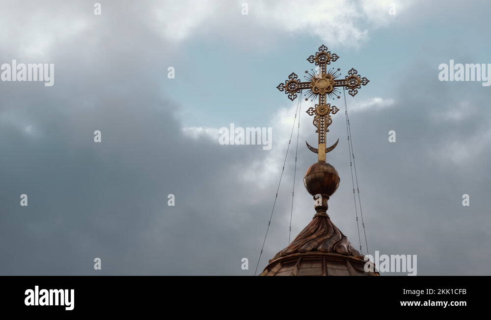 Christian cross on the dome of an Orthodox church against a cloudy sky ...