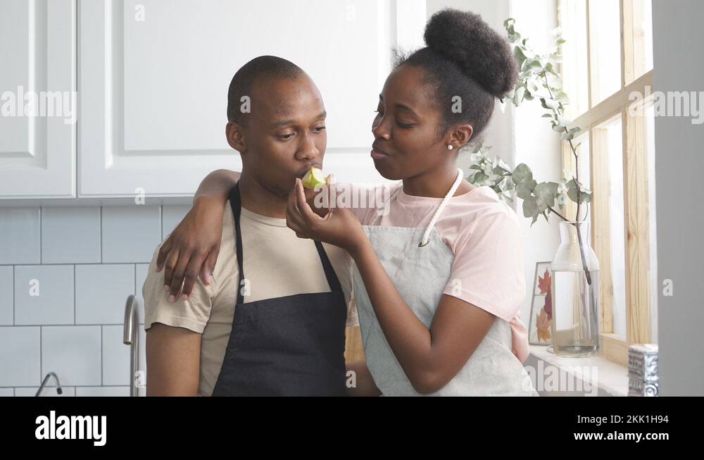 Happy married couple show their tender feelings while cooking Stock