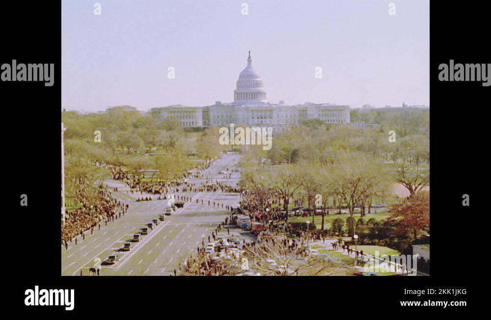 1960s Horses pull carriage with casket down road in funeral procession