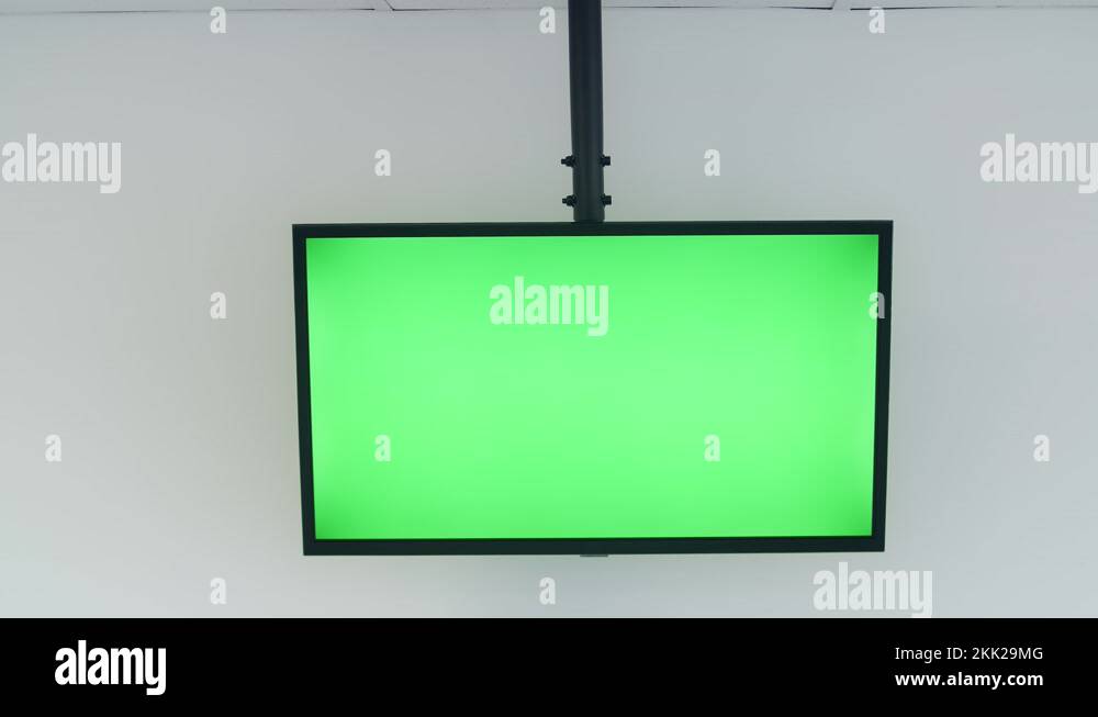 Big green screen TV in a white well lit conference room with nobody in