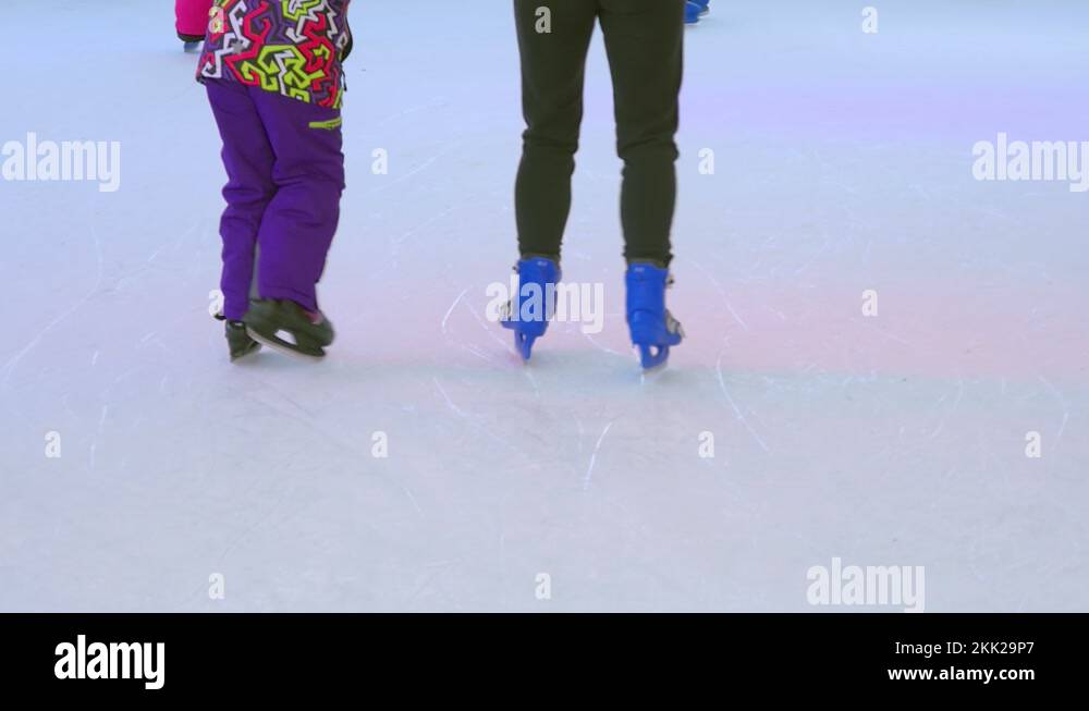Closeup on skaters learning to ice skate on artificial ice rink. Close