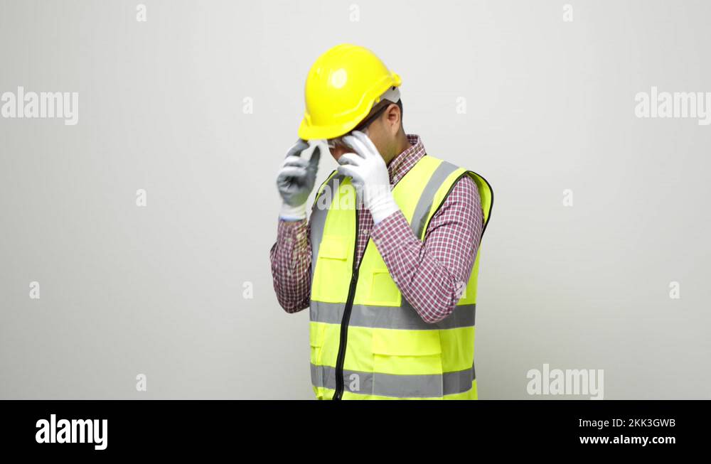 Smiling young asian civil engineer wearing safety glasses and helmet