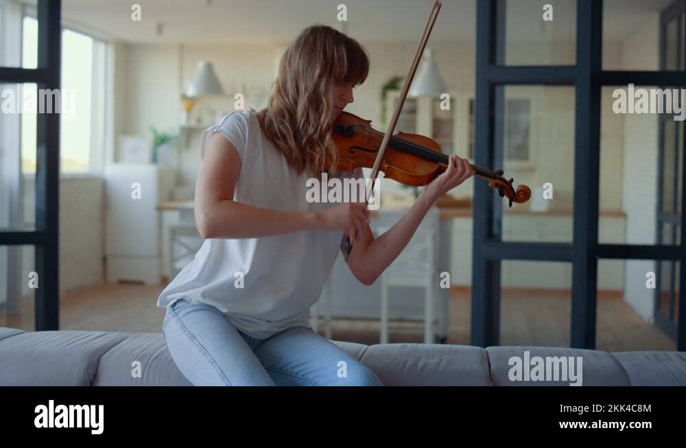 Teenage girl playing violin. Violinist playing chords on musical