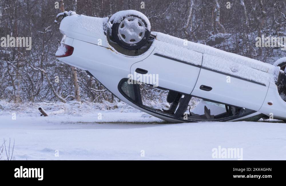 Car upside down in a serious accident on a frozen and snowy road amidst