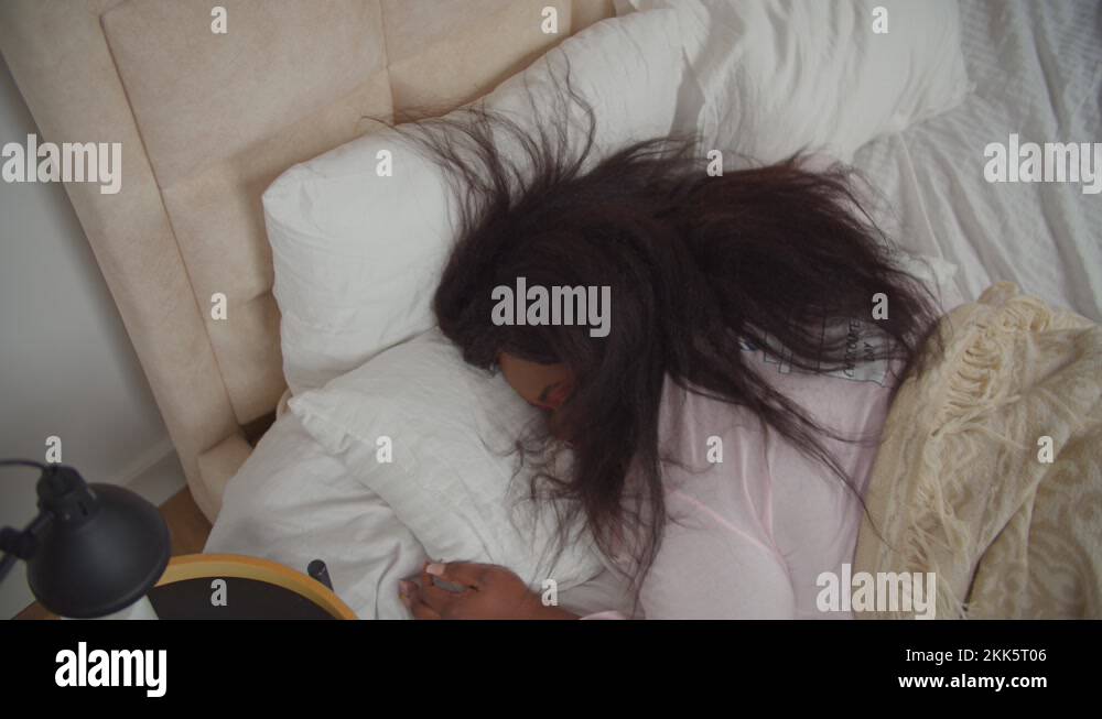 Exhausted female falling asleep in bed at night Stock Video Footage Alamy