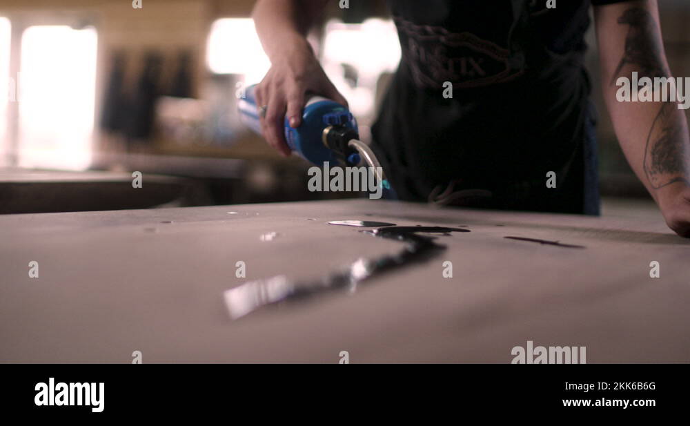 Female Woodworker Using A Butane Torch To Heat Epoxy Resin For Wood Art