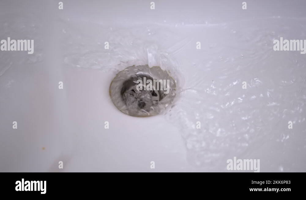 Drain Hole in Sink is Clogged. Bubbling Water Pours Into a Clogged