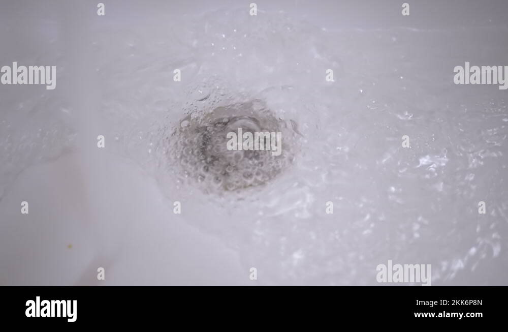 Drain Hole in Sink is Clogged. Bubbling Water Pours Into a Clogged