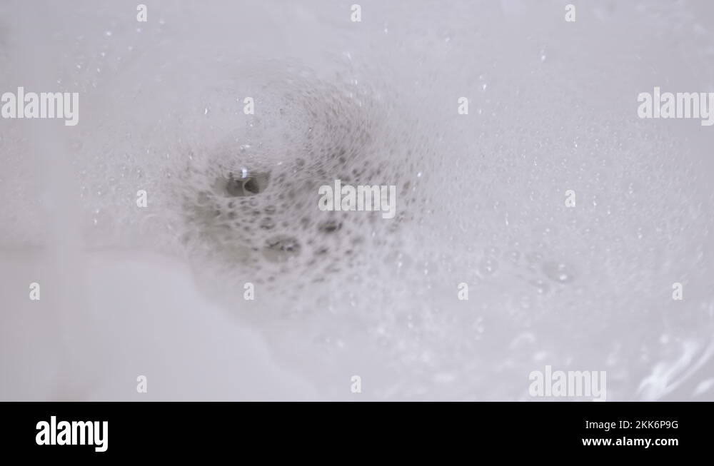 Drain Hole in Sink is Clogged. Bubbling Water Pours Into a Clogged