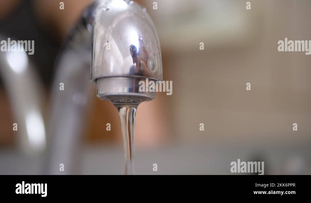 Open Water Tap. Stream of water quickly flows in Sink. Stream of Water
