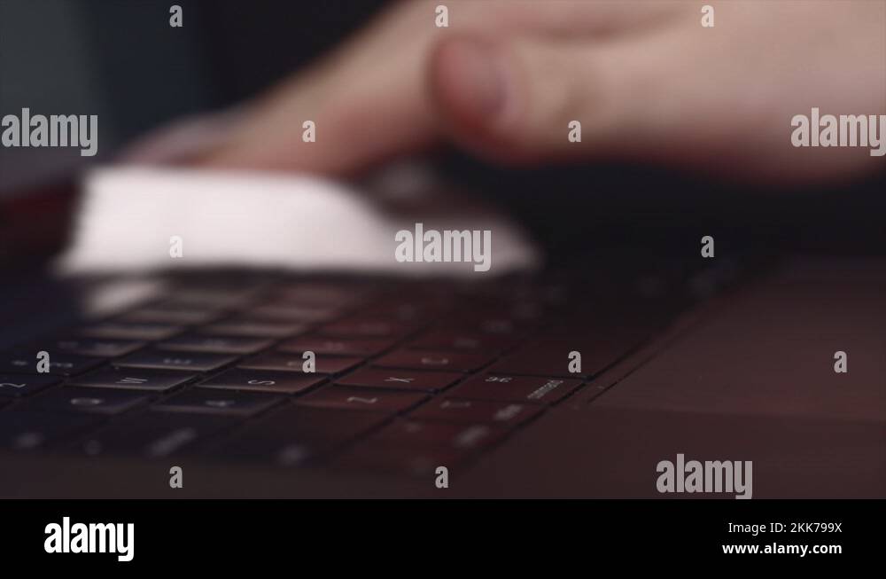 Cleaning laptop keyboard with wet wipe on working place. Personal
