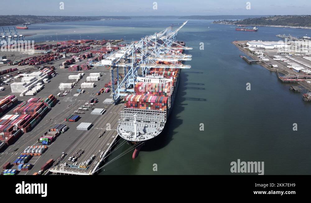 A giant container ship moored at Huskey Terminal being unloaded, aerial ...