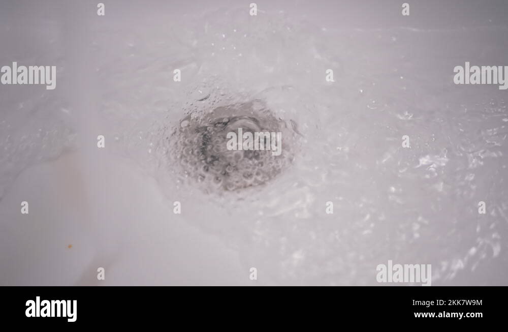 Drain Hole in Sink is Clogged. Bubbling Water Pours Into a Clogged White Sink Stock Video
