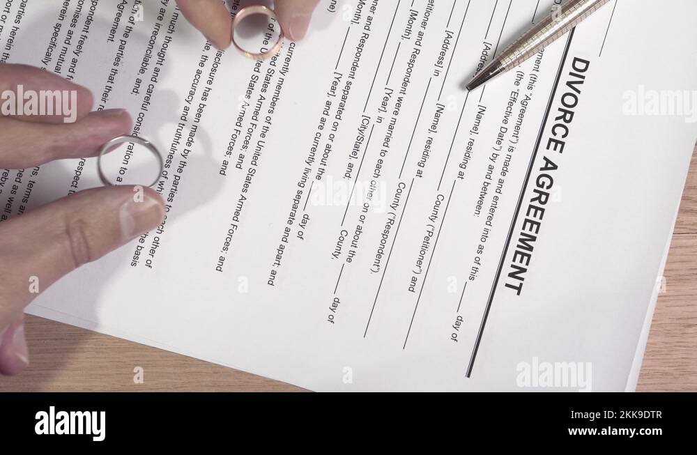 Divorcing couple puts their wedding rings on divorce document Stock