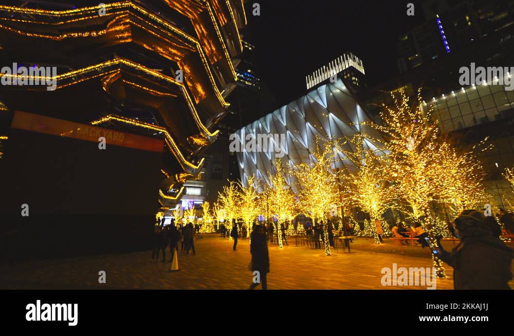 Many illuminated trees surround the Vessel by Christmas lights at