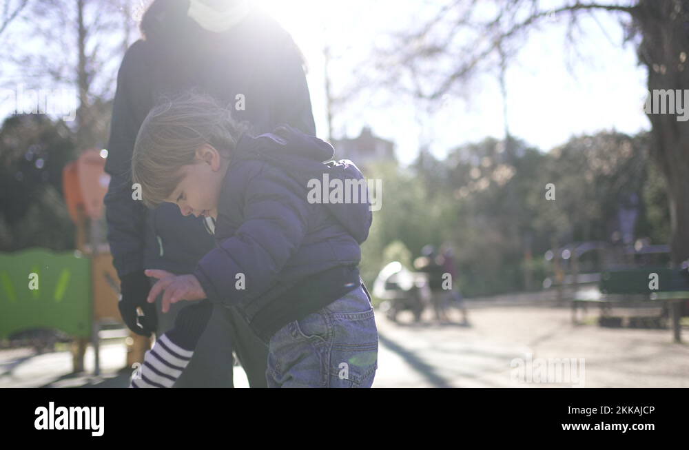 Toddler boy falling down on floor at playground park outside Stock