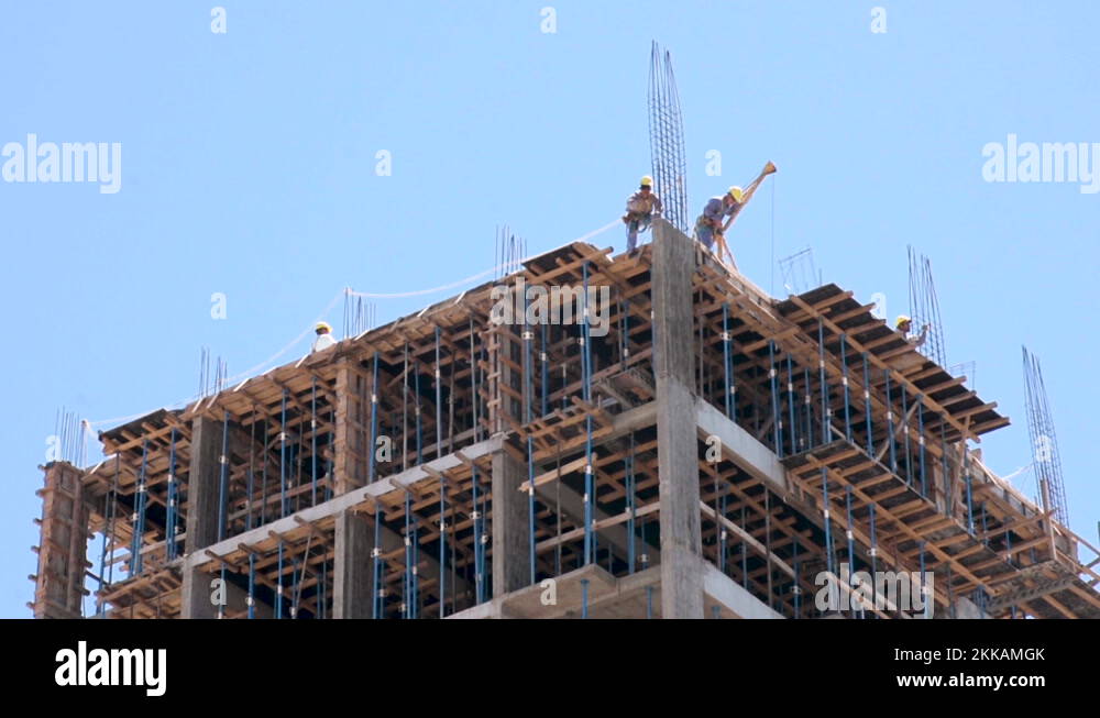 Male Construction Workers in Yellow Hard Hats on Top of High Rise
