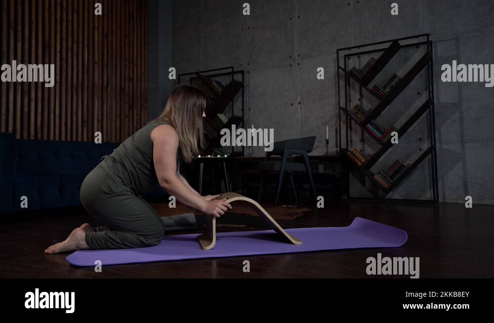 home gymnastics for spinal with special stand, woman is doing exercise