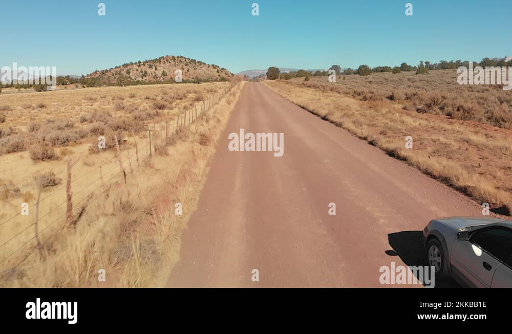 Silver Station Wagon with Bike Rack Smoothly Drives Over Washboard Dirt