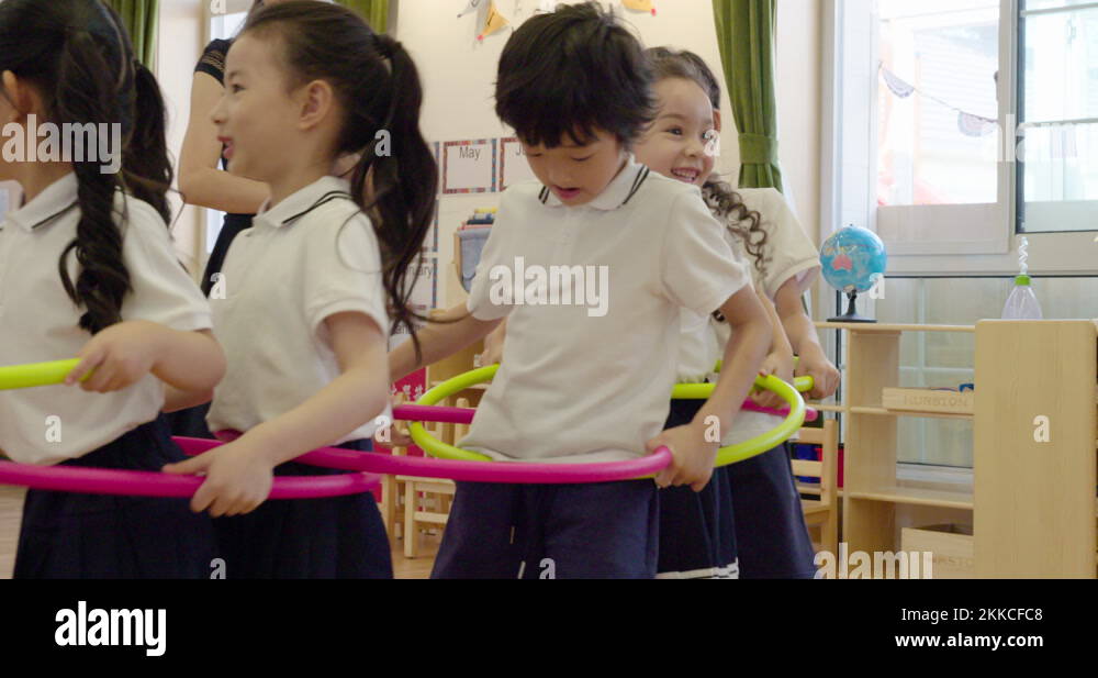 Chinese teacher and children playing games in kindergarten classroom,4K