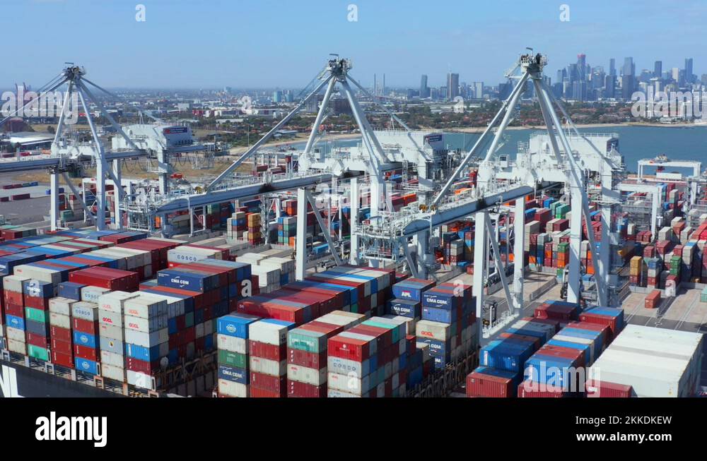 Crane ascends over container ship unloaded under the Melbourne city