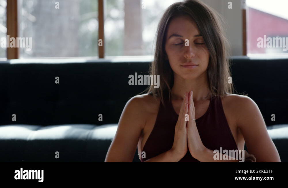 Attractive woman breathing deeply in Anjali Mudra yoga pose during