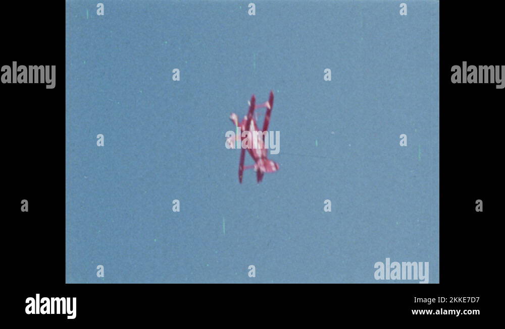 1970s Plane flies in sky, twists, rolls, and spins. Pilot flies plane