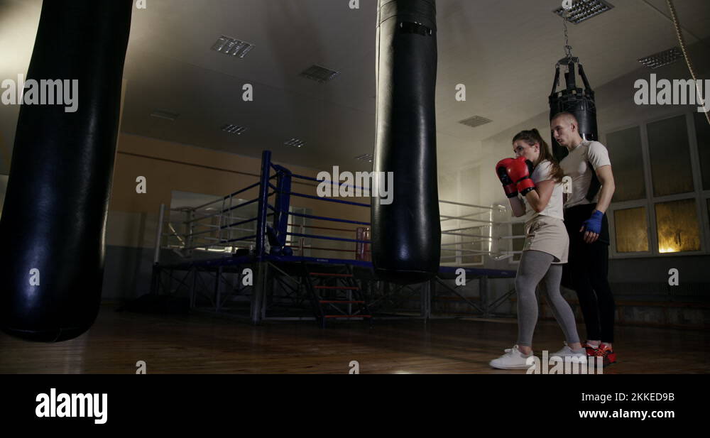 Strong woman boxing in boxing gloves practicing punches on a boxing