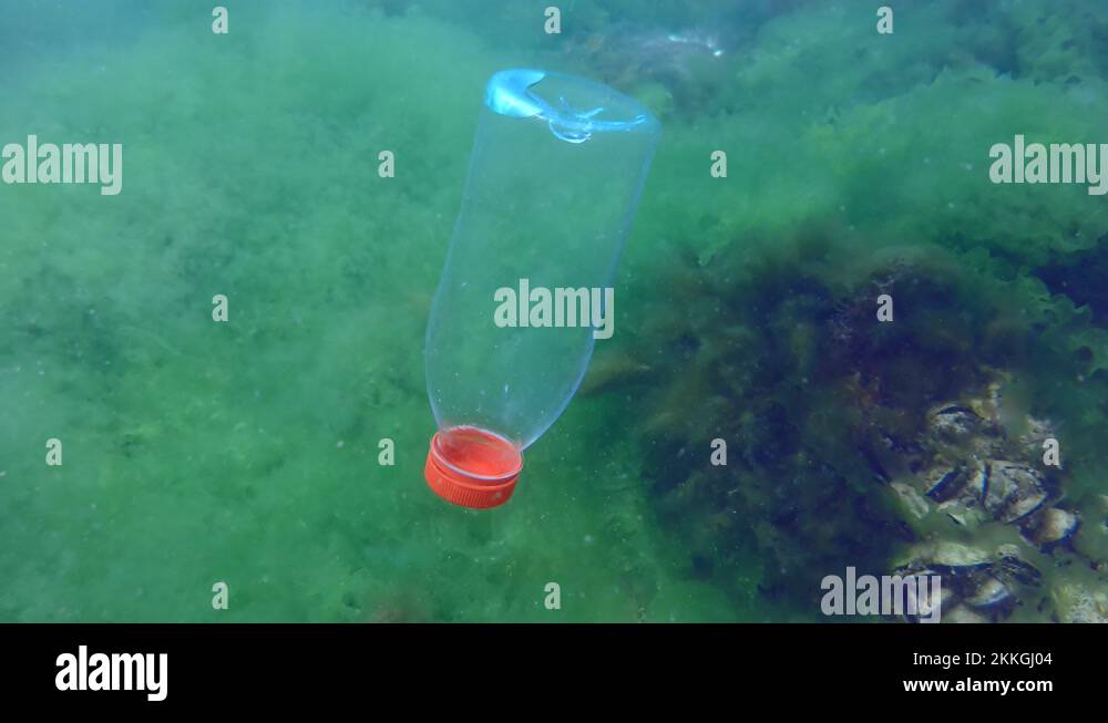 Plastic pollution of the sea PVC bottle slowly sinks to the bottom