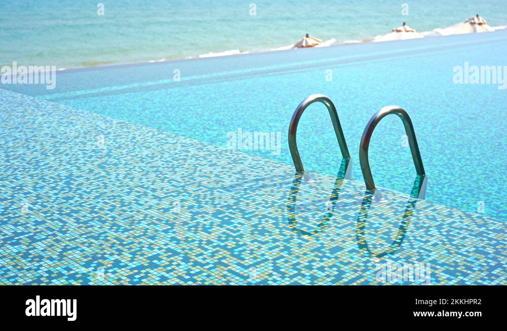 A pool ladder peaks out the deep end of the water to a shallow ledge Stock Video Footage Alamy