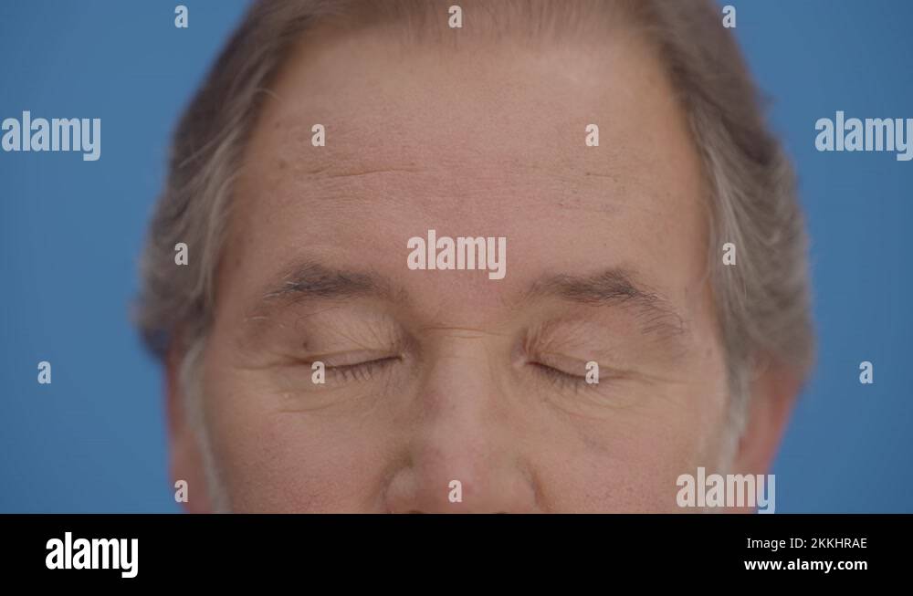 Bearded old man looks ahead by blinking his eyes, eyes plan Stock Video