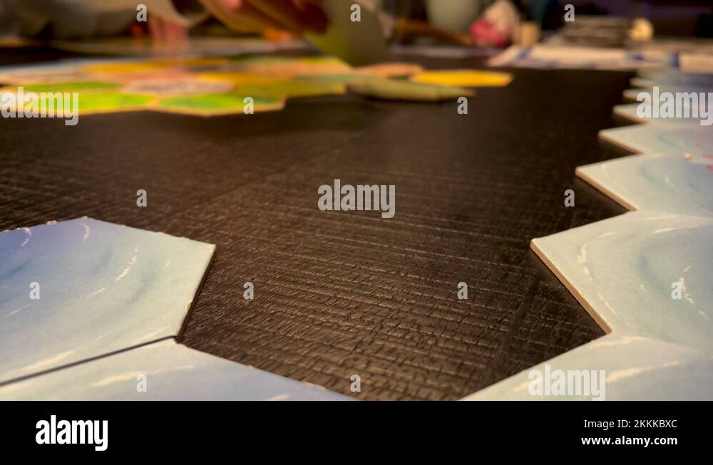 Hands Placing Hexagonal Tiles On The Table. Playing Family Board Game