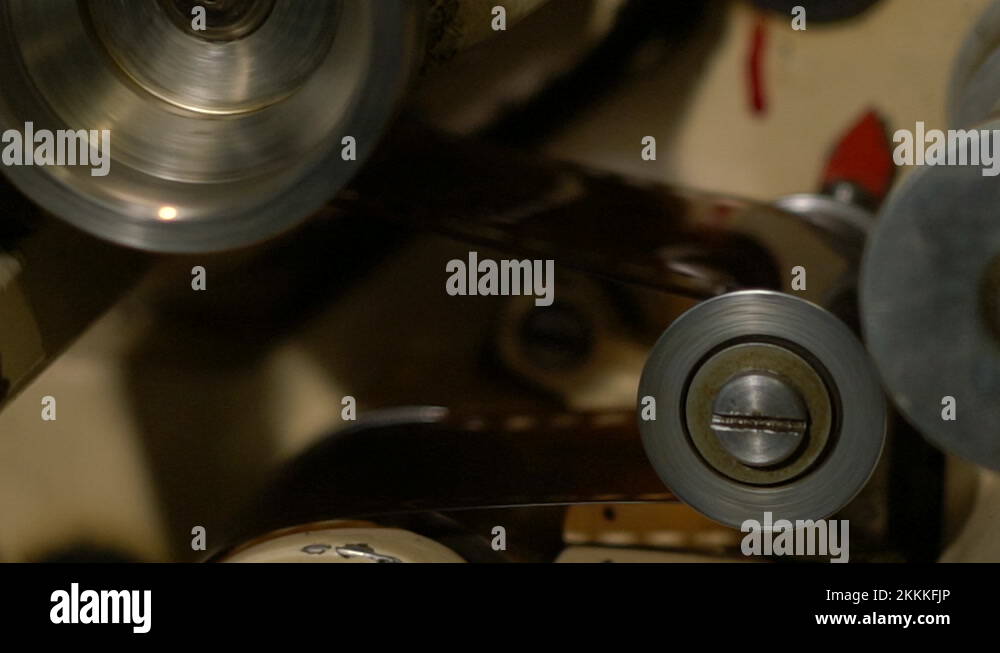 The film in the film projector mechanism slowly stops on the rollers