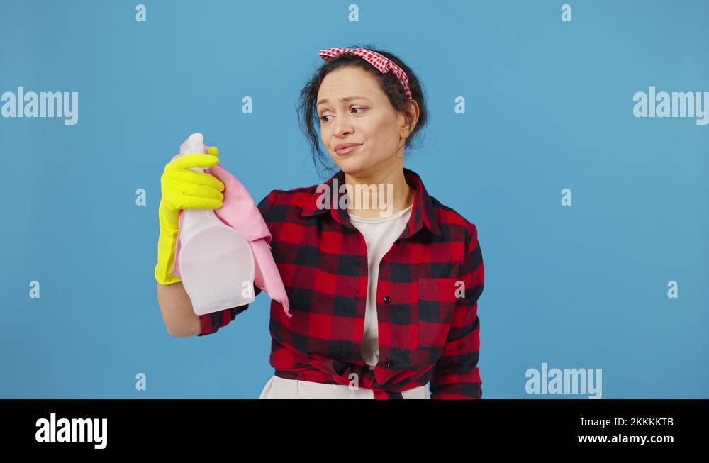 Exhausted housewife tired of cleaning, showing rag and spray cleanser ...
