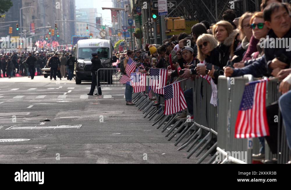 People cheering for Veterans Day Parade with USA Flags, waiting for ...