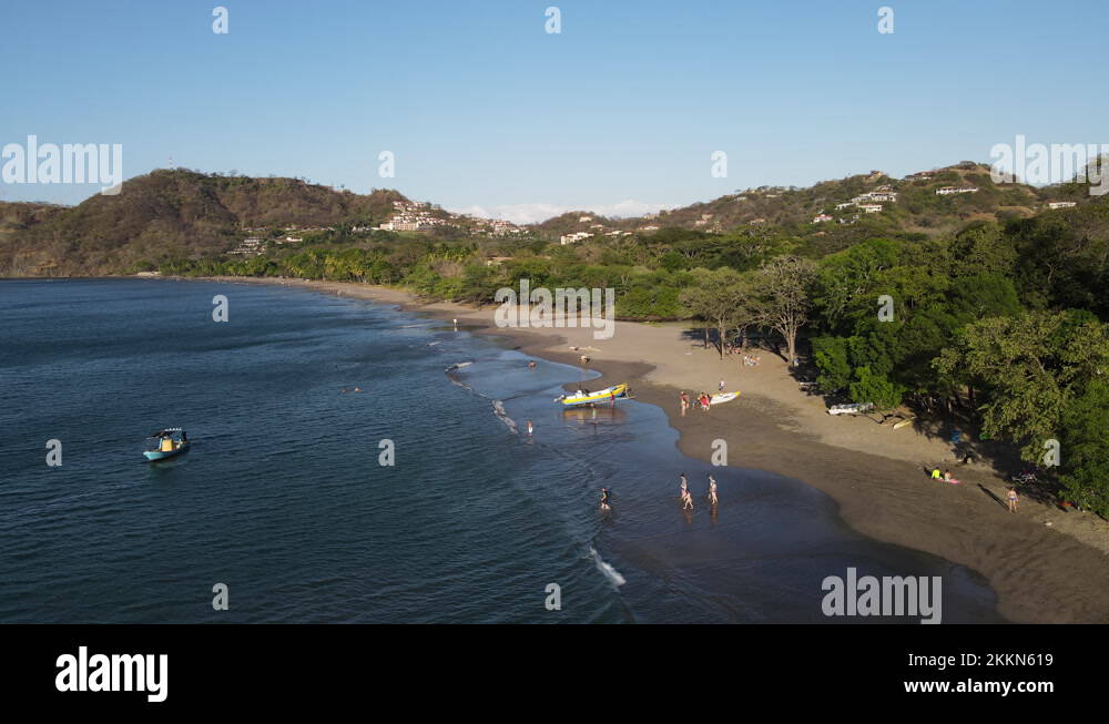 White sand beach with tourists sunset Costa Rica aerial Guanacaste