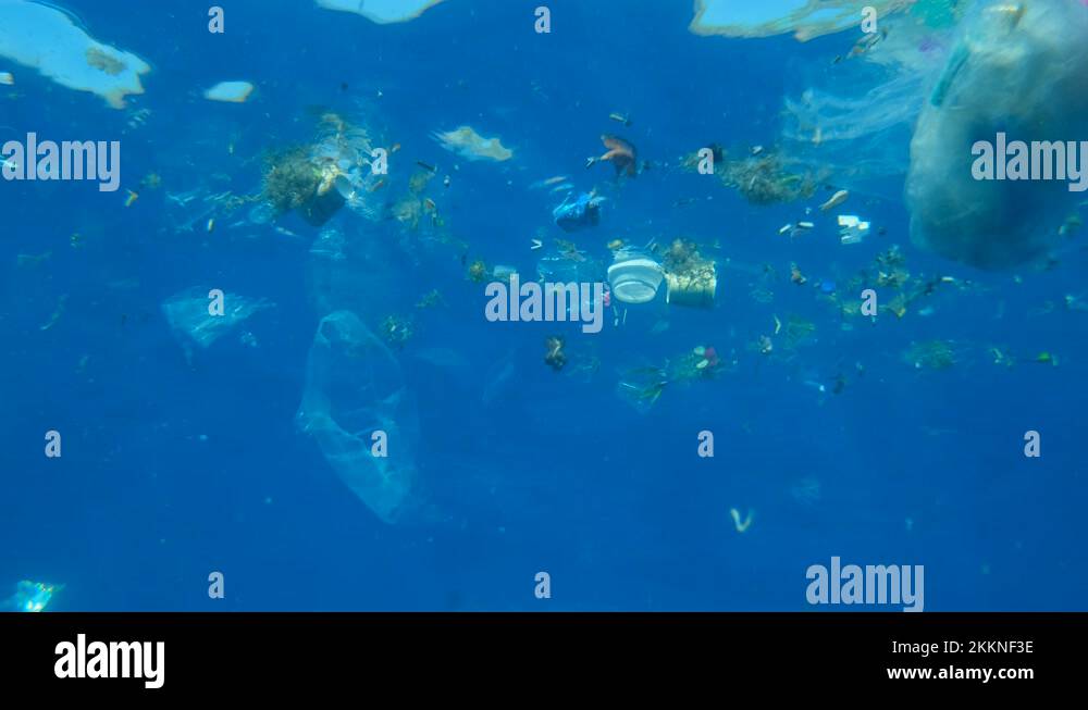 Plastic pollution of the Ocean. Plastic cups and plastic bags drifts